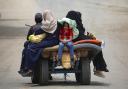 Palestinians sit on an animal pulled cart as they move to safer areas in Rafah