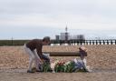 A woman lays flowers for Hossam Al-Khawas