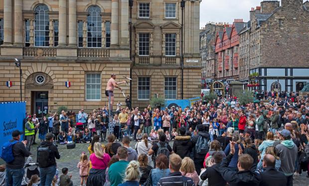 The National: Alamy Live News. 2GDHF61 Royal Mile, Edinburgh, Scotland, UK. 13th August 2021. Showery weather and 18 degrees in the capital city for the beginning of the second week of the Edinburgh Fringe Festival. Pictured: Pete Anderson entertains the audience West