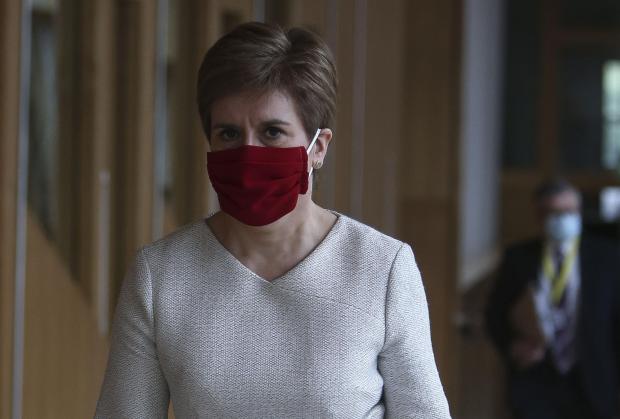 The National: Nicola Sturgeon on her way to the Holyrood chamber on Tuesday, where she announced that enforcement of the vaccine passport scheme was to be delayed