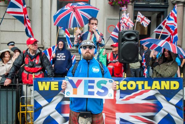 The National: Around ten thousand people march down Union Street in Aberdeen to show there support for Scottish independence...Photos of a unionist counter protest. A YES protester stands in front of it...Photo by.Michael Traill.9 South Road.Rhynie.Huntly.AB54
