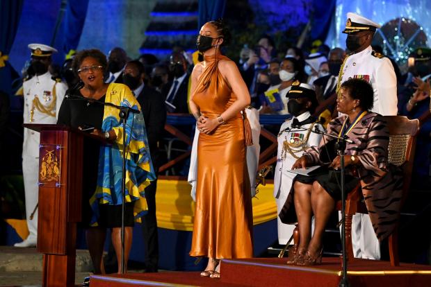 The National: Barbados PM Mia Mottley, left, and president Dame Sandra Mason, right, honour Rihanna as a national hero