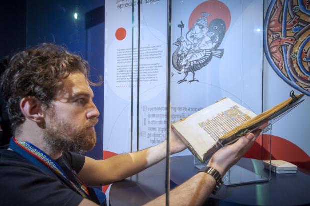 The National: Conservation Exhibitions Specialist Ryan Gibson installing the Iona Psalter | Credit: Neil Hanna