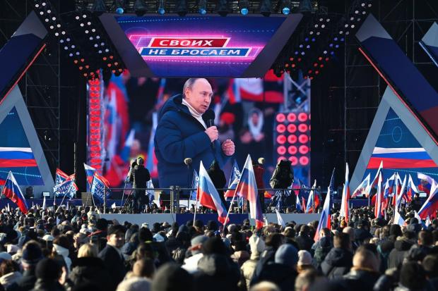 Vladimir Putin attends a concert in Moscow to mark the eighth anniversary of a referendum on the status of Crimea and Sebastapool. The banner reads 'For Russia'. Picture: Vladimir Astapkovich Sputnik Pool Photo via AP