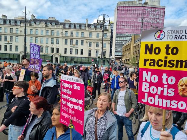 The National: Demonstrators protesting in George Square, Glasgow against the government plans to send migrants to Rwanda
