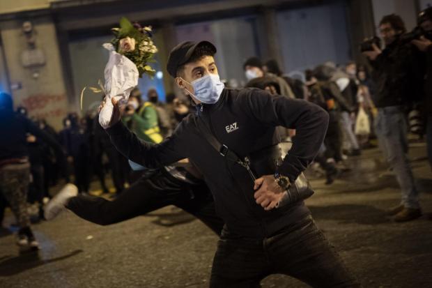 The National: A man throws a bouquet of flowers against a national police station during a protest condemning the arrest of rap singer Pablo Hasel in Barcelona, Spain, Monday, February 22, 2021