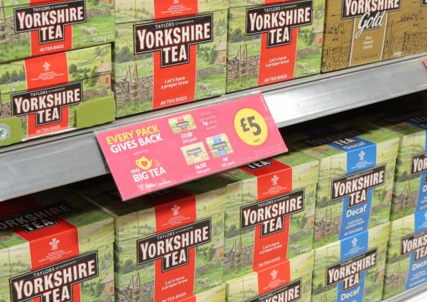 The National: Teabags on shelves and a Every Pack Gives Back label at a Morrisons store (Morrisons)