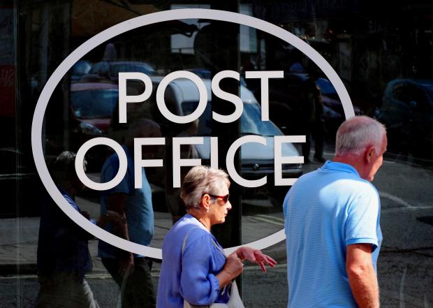 The National: People walking outside a Post Office. Credit: PA
