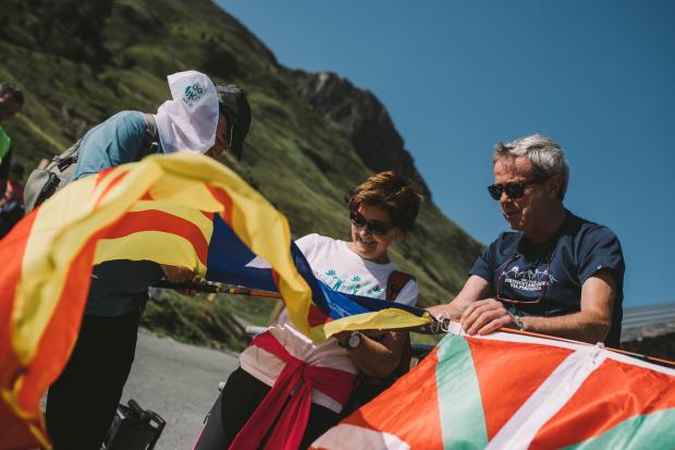 The National: Activists tie Catalan and Basque flags to a pole at the Pyrenees event