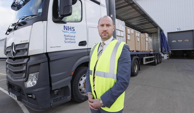 The National: Neil Gray, Minister for International Aid and Refugees with a fully loaded HGV at the NHS Supply depot in Bellshill and ready to depart with over 500,000 pieces of medical supplies and equipment to Ukraine.
