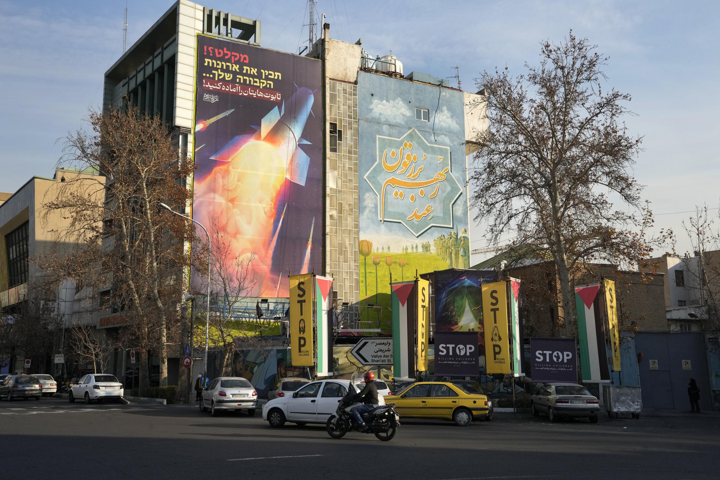 Vehicles drive past an anti-Israeli mural showing a launched missile with sign in Farsi reading Death to America, at the Felestin (Palestine) Sq. in downtown Tehran, Iran, Thursday, Jan. 18, 2024. The sign on top reads in Farsi and Hebrew: Prepare