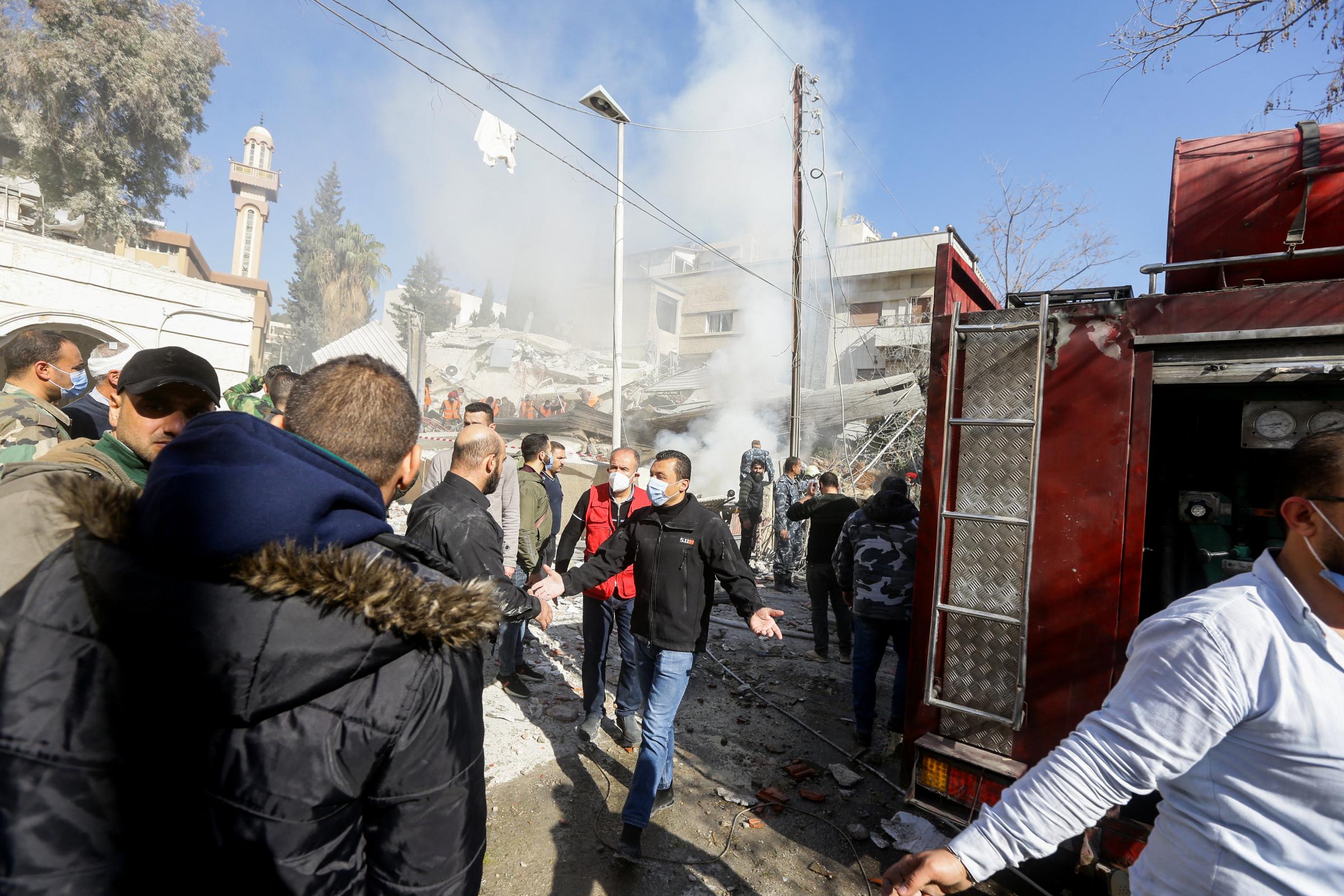 Security and emergency personnel deploy around a building destroyed in a reported Israeli strike in Damascus on January 20, 2024. An Israeli strike on Damascus killed the Iranian Revolutionary Guards intelligence chief for Syria and three other Guards