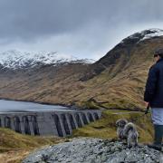 A boy and his dog view Cruachan hydro electric power station in Argyll
