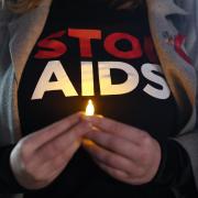 A woman holds a candle at a World Aids Day event