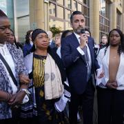 Sheku's mother Aminata Bayoh (2nd left) with Sheku's sisters as lawyer Aamer Anwar (centre) speaks to supporters outside Capital House in Edinburgh. Photo: PA