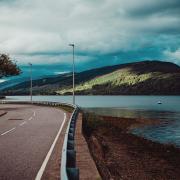A road along the shore of Loch Fyne, home to award-winning restaurant Inver. Photo by Aleks Marinkovic on Unsplash