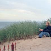 Susan Munro relaxing among the tall grass and sand