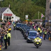 The hearse carrying the coffin of Queen Elizabeth II passing through Ballater as it continues its journey to Edinburgh from Balmoral.