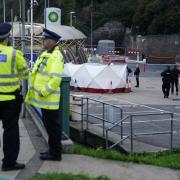 Police officers by a tent around the car allegedly involved in an incident near the migrant processing centre in Dover, Kent
