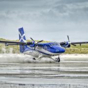 A Twin Otter aircraft, operated by Loganair, departing Barra airport on Traigh Mhor beach