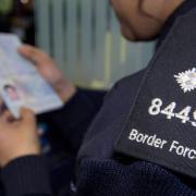 A file photograph of a UK Border Force officer inspecting a passport
