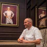Head chef, Stephen McLaughlin with a painting of the late founder, Andrew Fairlie