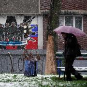 A pedestrian walks past a defaced mural to the glory of Russia's mercenary group Wagner