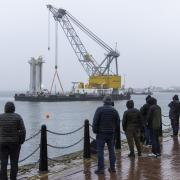 Salvage teams at Victoria Harbour recover a tugboat from the water in the Firth of Clyde