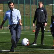 Humza Yousaf plays football during a visit to a school holiday club at Ayr Academy in Ayr, to announce additional funding to support families.