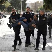 Israeli police detain a Palestinian in the Al-Aqsa Mosque compound following a raid of the site in the Old City of Jerusalem during the Muslim holy month of Ramadan