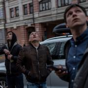 Pedestrians observe Kyiv's air defence systems trying to down a drone