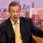 Nigel Farage holding up the 50p Brexit coin - which he would currently be unable to deposit in a UK bank