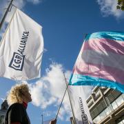 An activist holds a transgender pride flag outside the first annual conference of the LGB Alliance