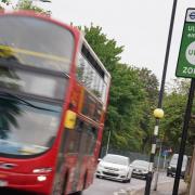 A London bus passes an information sign for the Ultra Low Emission Zone (Ulez) in London