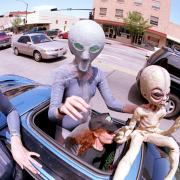 Groups dressed as aliens ride through downtown Roswell, New Mexico July 1, 2000 as they participate in the annual UFO Encounter