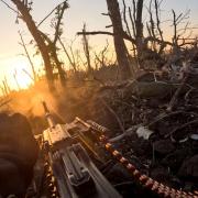 A Ukrainian servicemen fires a machine gun towards Russian positions near Andriivka, Donetsk