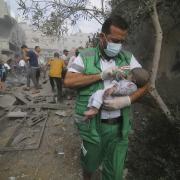 Palestinian medic takes a baby pulled out of buildings destroyed in the Israeli bombardment of the Gaza Strip in Rafah