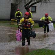 Members of the emergency services carry residents belongings to safety in Brechin