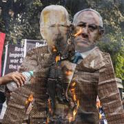 Activists of Socialist Unity Center of India (Communist) burn an effigy of U.S. President Joe Biden and Israeli Prime Minister Benjamin Netanyahu during a rally to protest against Israel's military operations in Gaza