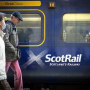 Commuters walking past a ScotRail train (Jane Barlow/PA)
