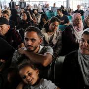 Citizens with foreign passports wait to travel through the Rafah crossing