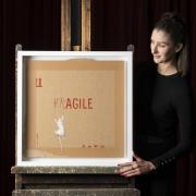 Auctioneer Amy Cameron with Banksy's AGILE, which is to go up for sale in Glasgow