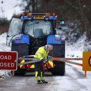 A plough man closes the snow gates on the A836 Scourie road on January 19, 2024 in Ardgay, Scotland
