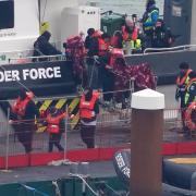 A group of people thought to be asylum seekers disembark at Dover