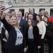Northern Ireland First Minister Michelle O'Neill takes a photo with her Sinn Fein party MLA colleagues on the steps of Parliament Buildings at Stormont.