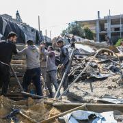 People inspect the damage to their homes following Israeli air strikes in Rafah