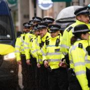 Police look on as climate protesters march though the City of London.