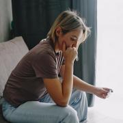 A stock image of a woman checking a pregnancy test