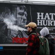 Members of the public walk past a hate crime billboard in Glasgow
