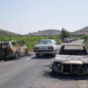 Torched vehicles are seen along the road in the West Bank village of al-Mughayyir (AP Photo/Nasser Nasser)